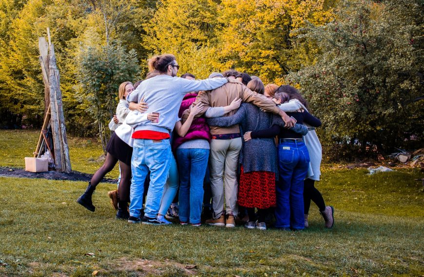 Grupo de jovens a abraçarem-se no meio da natureza.